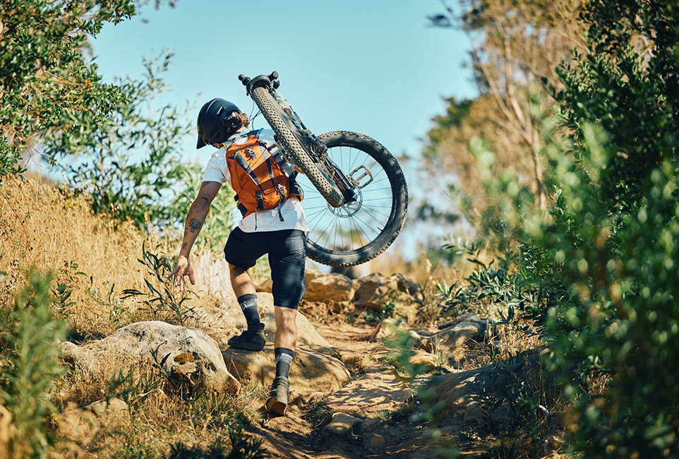 man-back-and-carrying-bicycle-in-nature-walking-an-ZQ5XCZ2